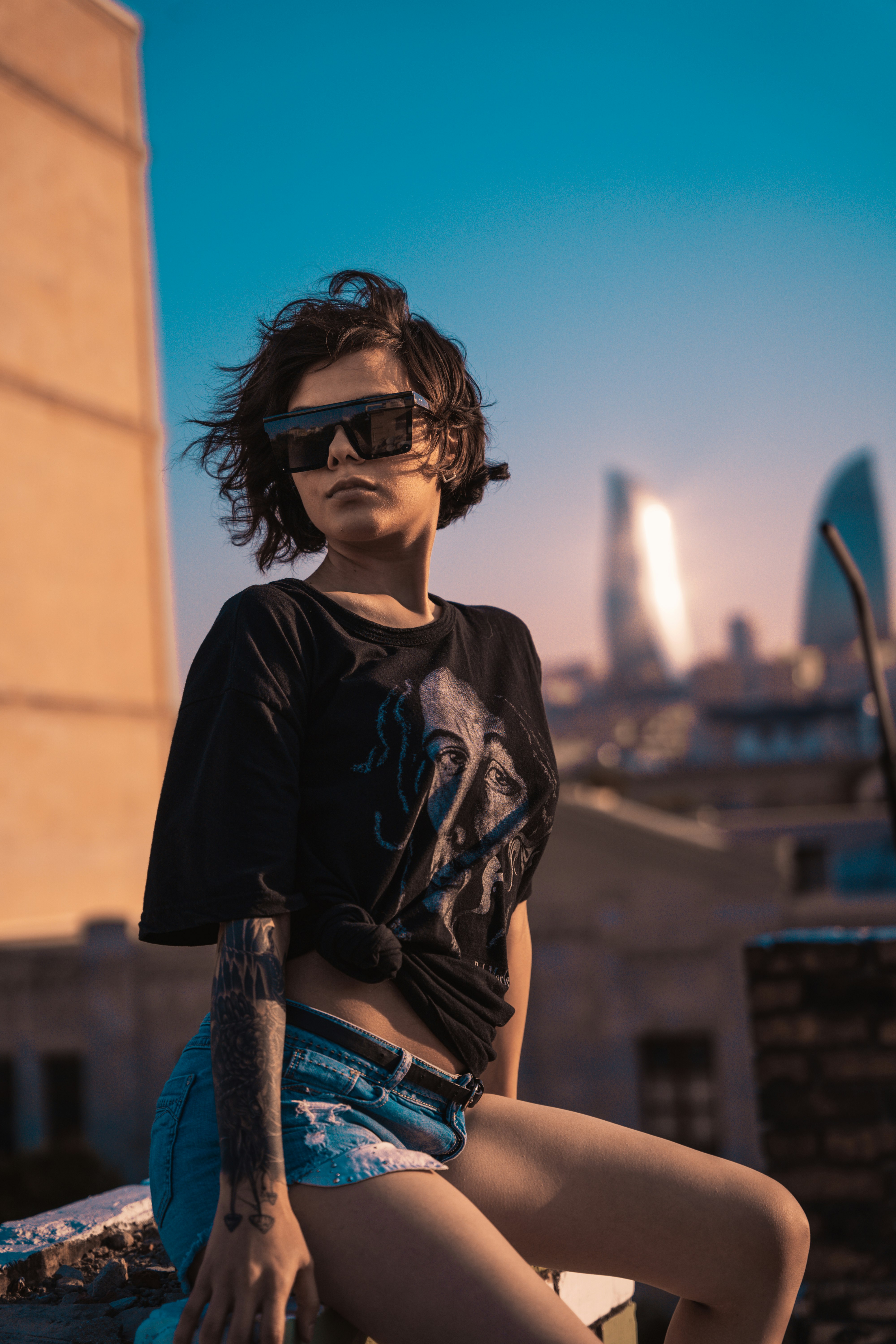 man in black crew neck t-shirt and blue denim jeans wearing black sunglasses